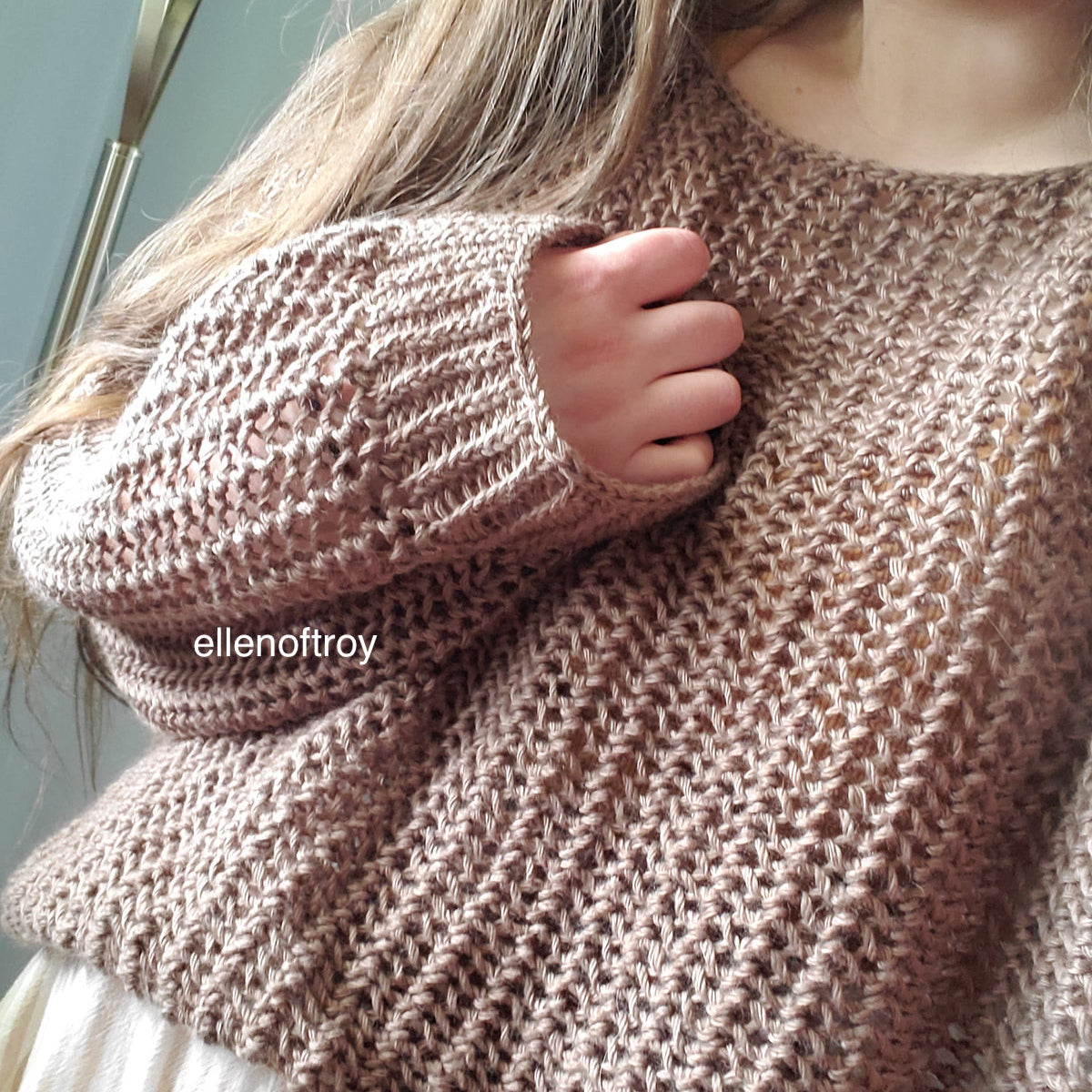 Close-up of a person wearing the Halcyon Lace Sweater in a warm brown shade.