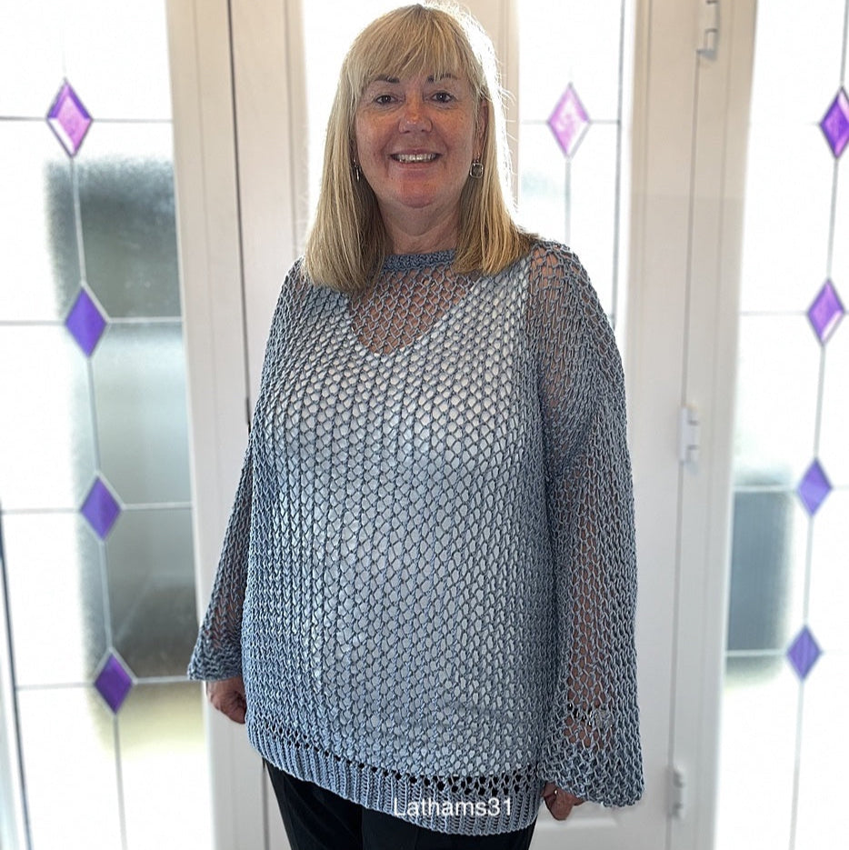 Smiling woman wearing the Halcyon Lace Sweater in a light blue shade