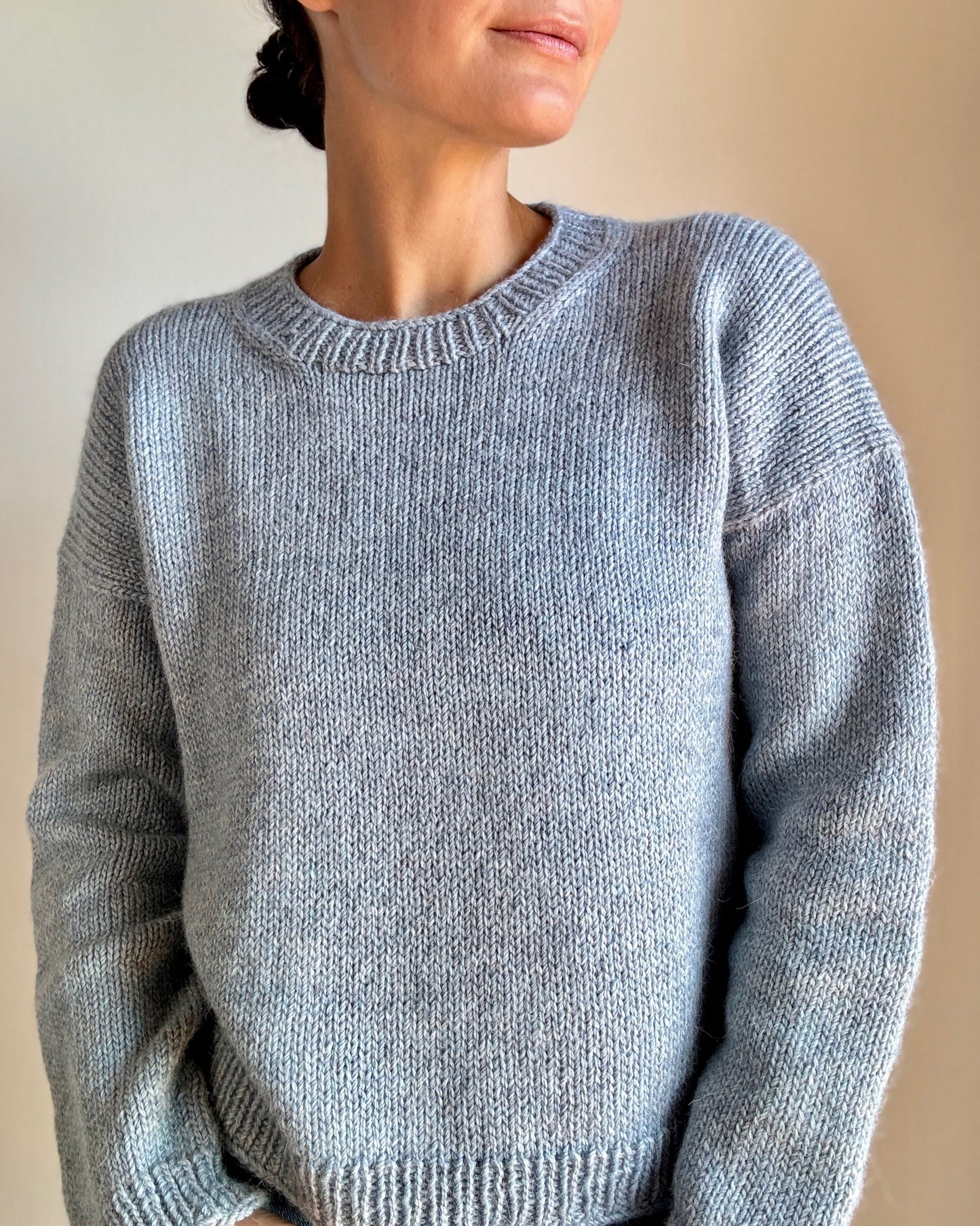 Woman wearing the hand-knit Drop in Dream sweater in blue