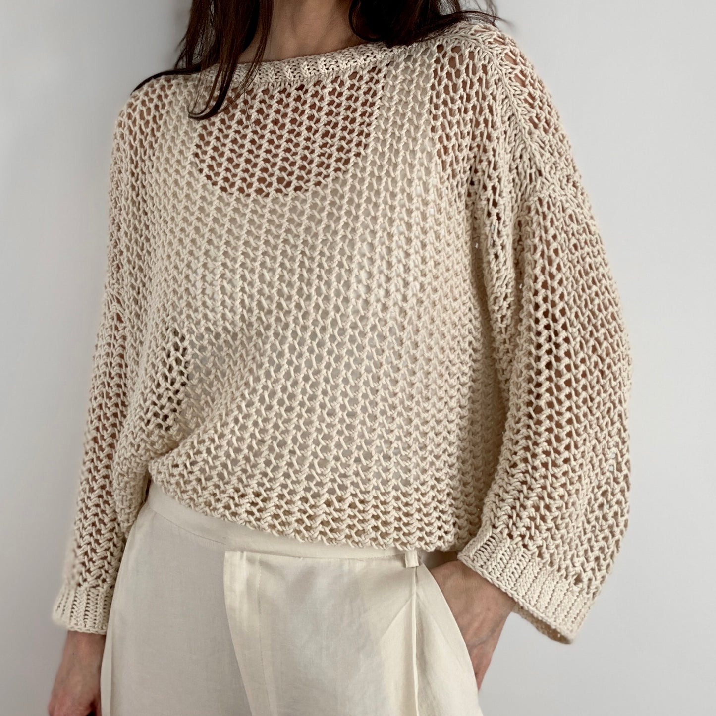 Close-up of a person wearing the Halcyon Lace Sweater in cream.