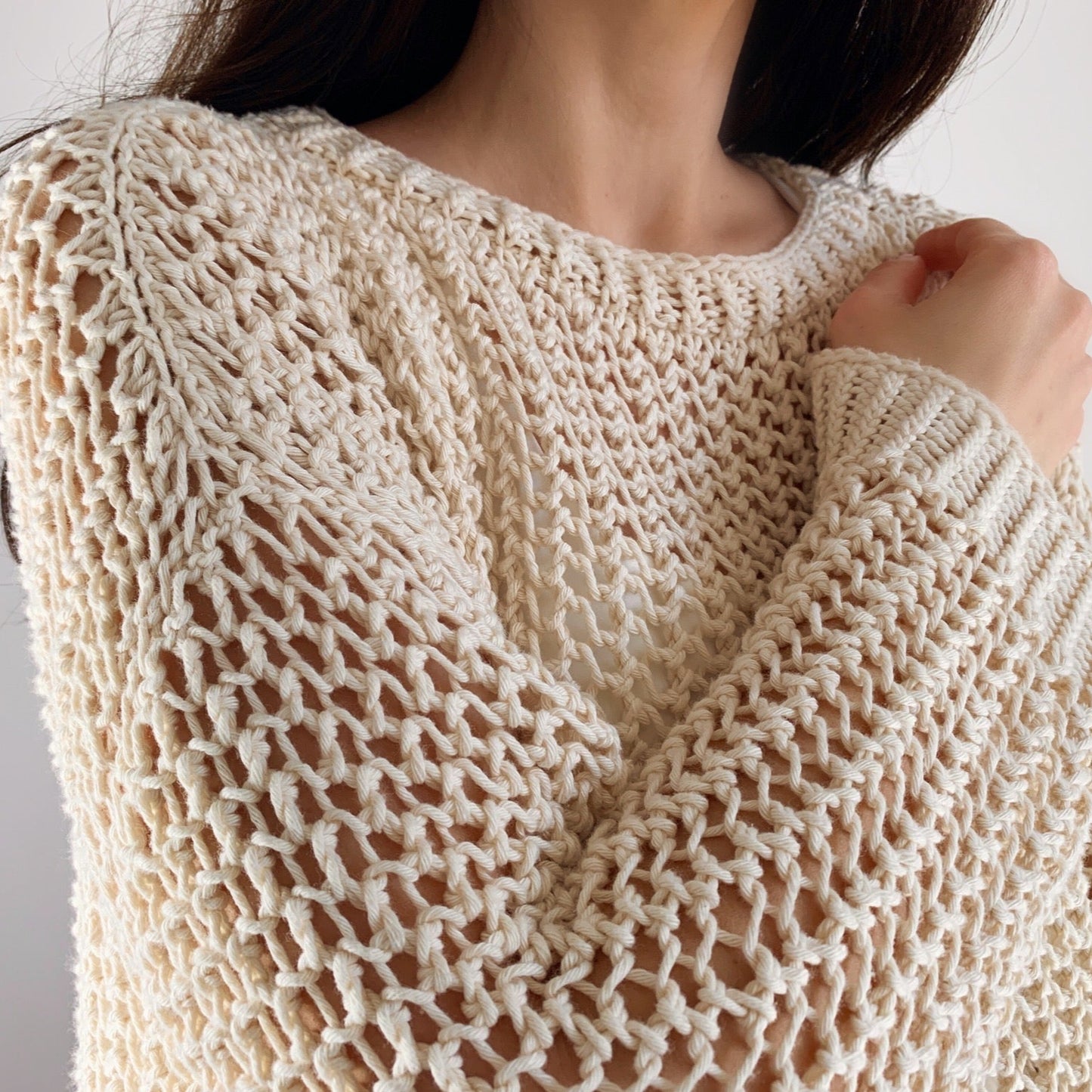 Close-up of a person wearing the Halcyon Lace Sweater in cream.