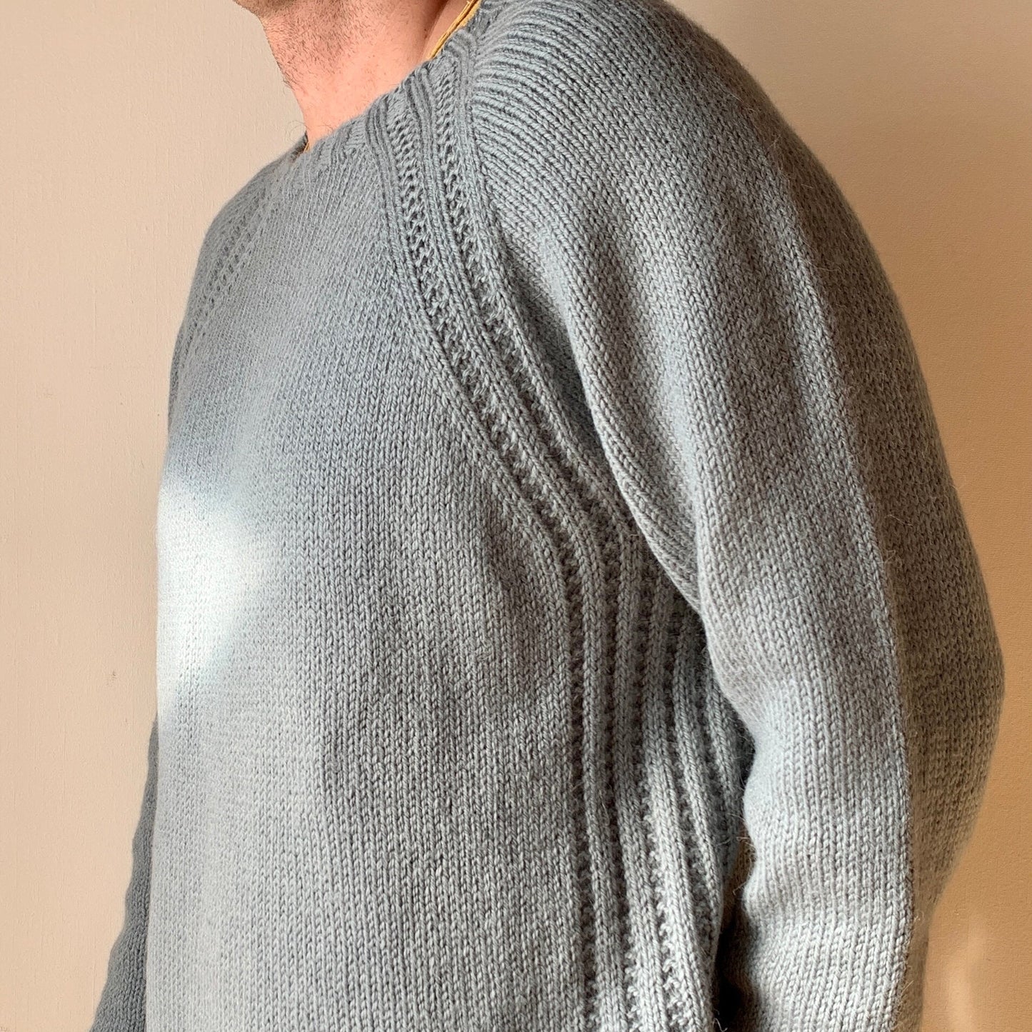 A close-up side view of a man wearing the His Mellow Mood Sweater in light gray