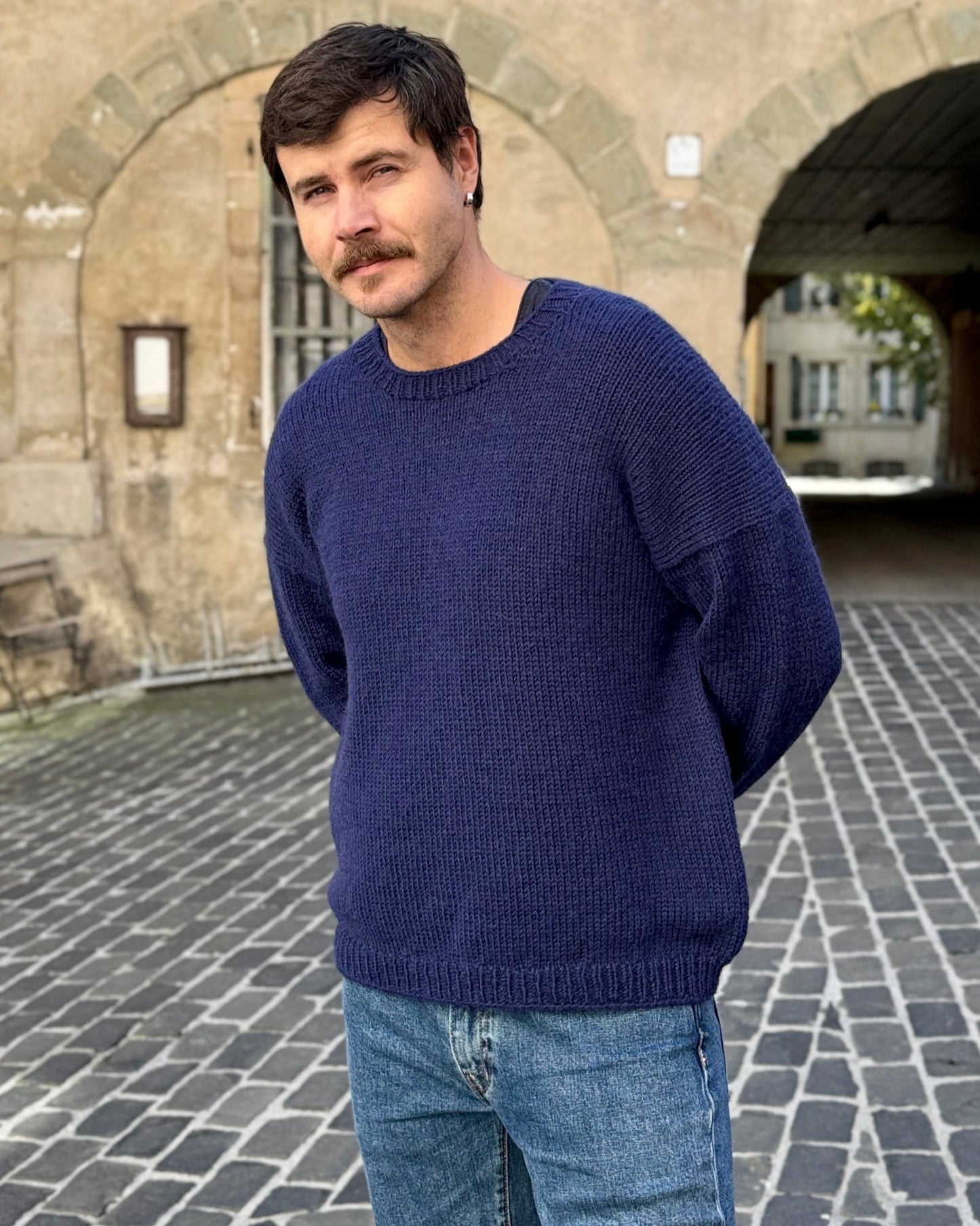 Man wearing the Drop in Dream sweater in navy blue, styled with jeans.