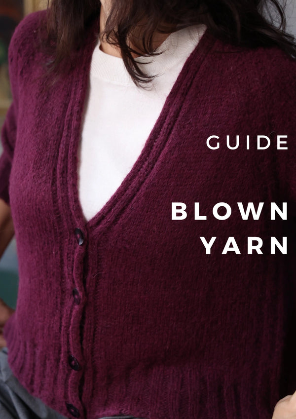 Maroon cardigan worn by a person with text 'GUIDE BLOWN YARN' on a blurred background